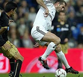 Vestindo a camisa do Real Madrid,&nbsp;Zidane aplica seu drible característico.
